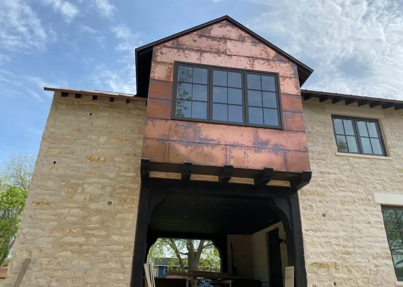 Copper metal panel facade on a stone building for Skylight Installation in Winterset